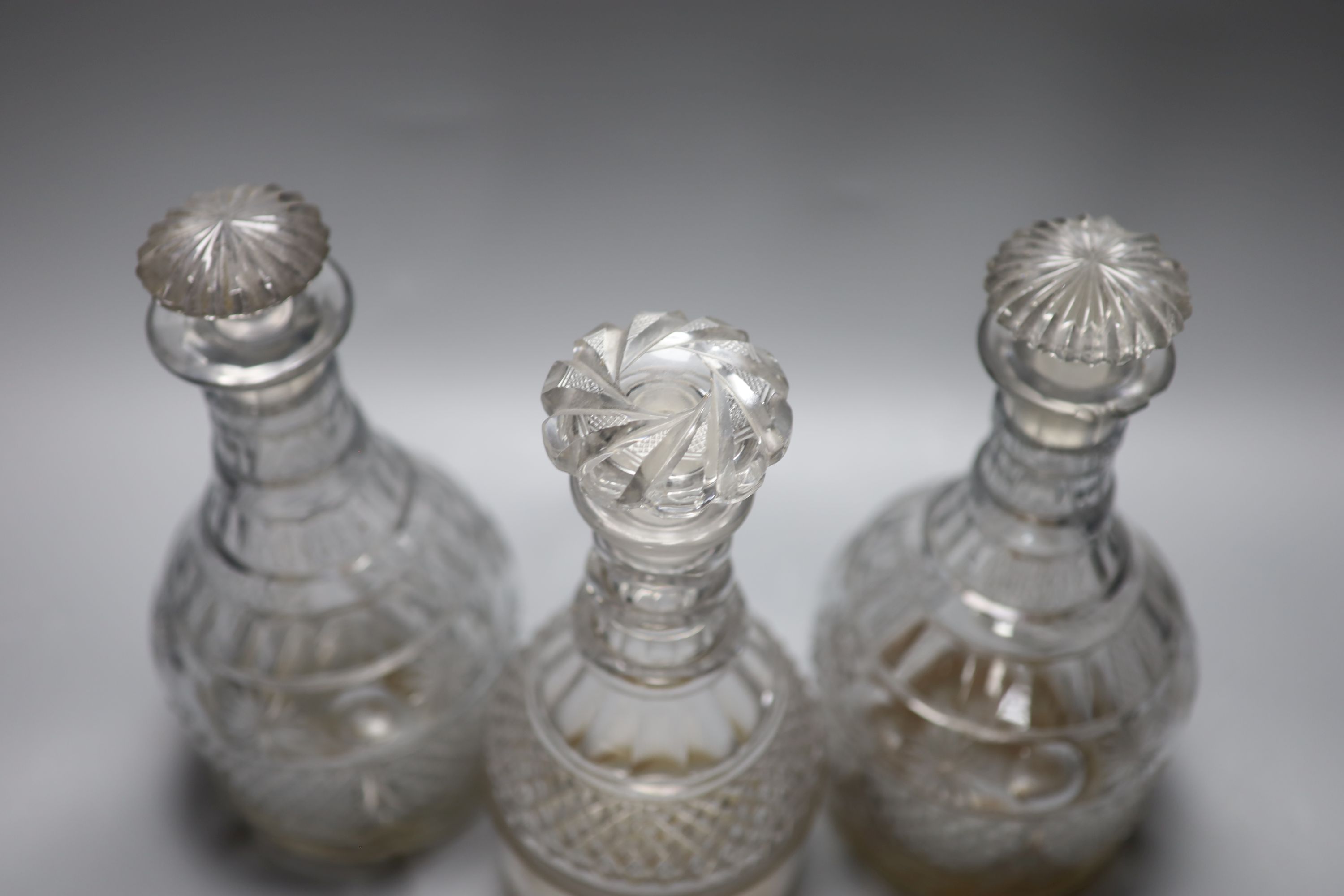 A pair of early 19th century cut glass decanters and one other